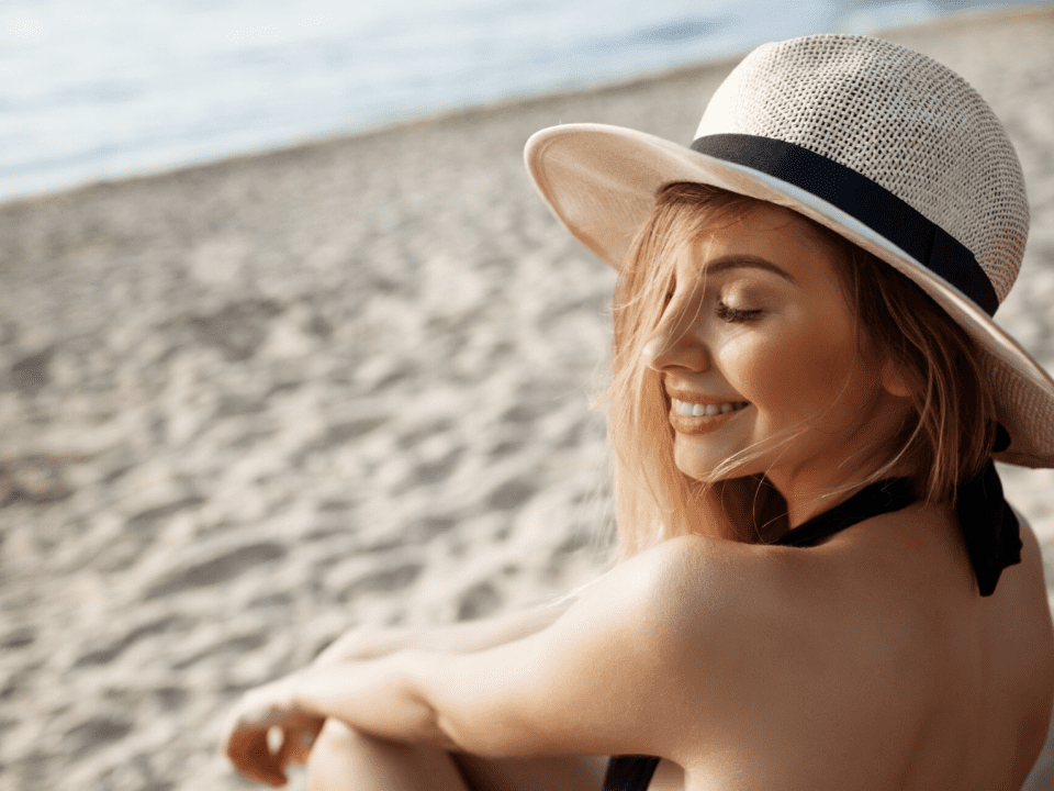 mujer en la playa exponiendo su piel un día de verano